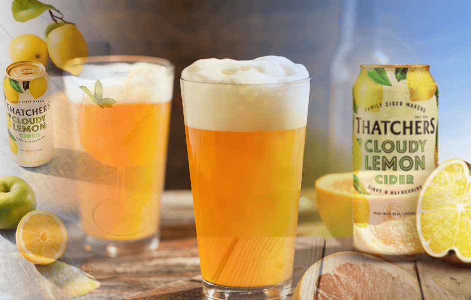 Glasses of cloudy lemon cider with fresh lemons and cans